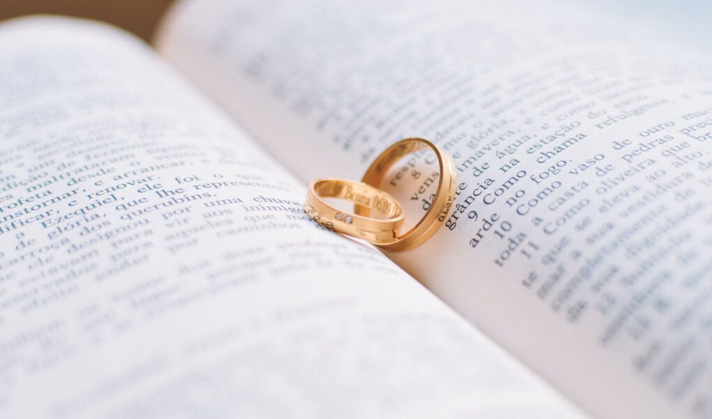 two gold colored wedding bands on book page