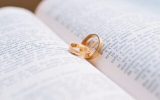 two gold colored wedding bands on book page