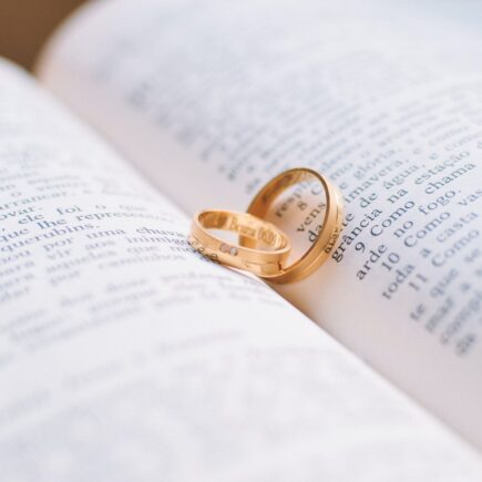 two gold colored wedding bands on book page