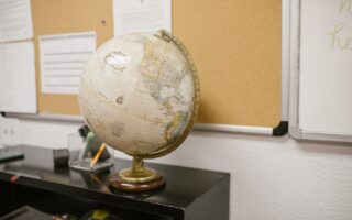 white and gold desk globe on black table